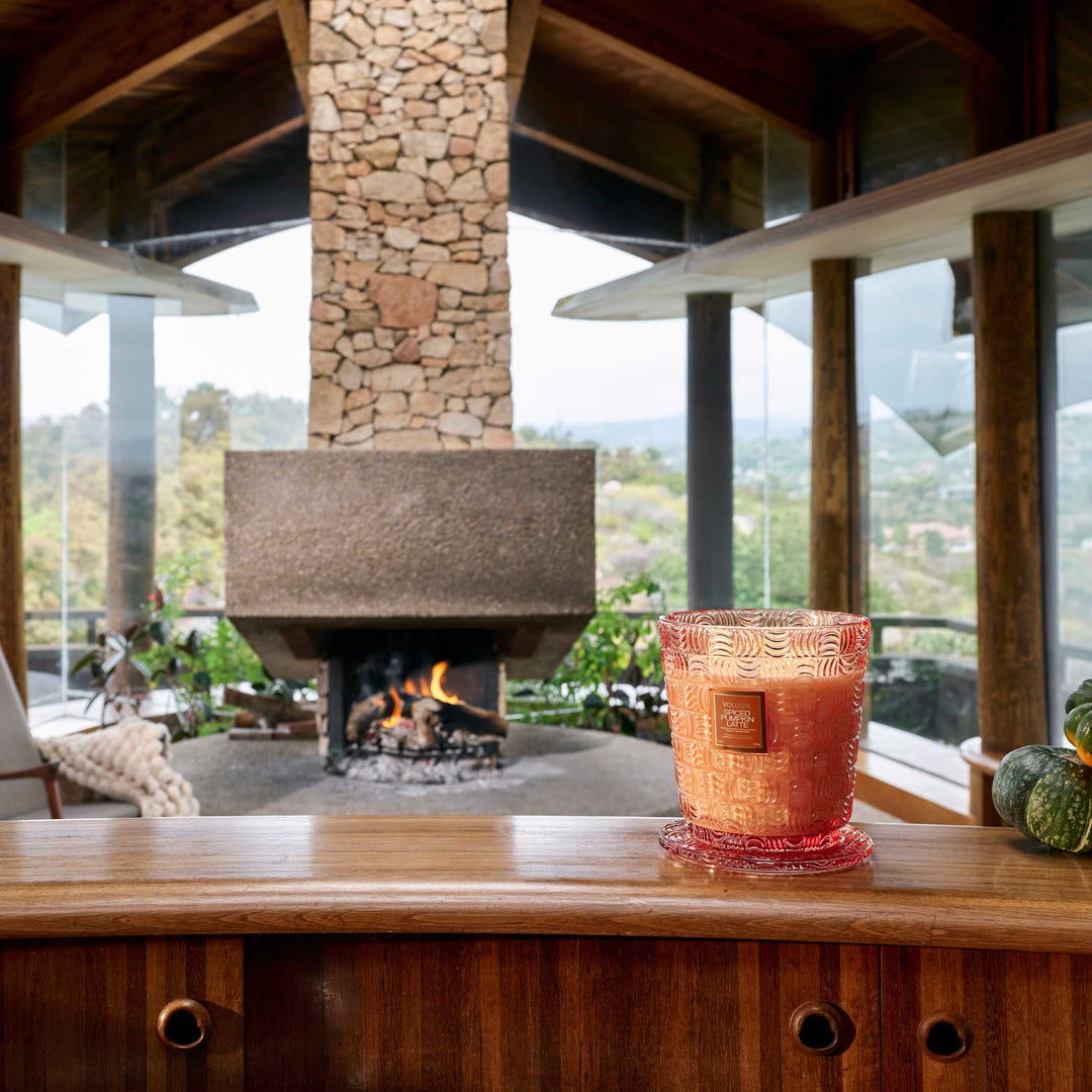 Voluspa Spiced Pumpkin Latte 5 Wick Hearth Candle displayed in a cozy fall interior near a fireplace
