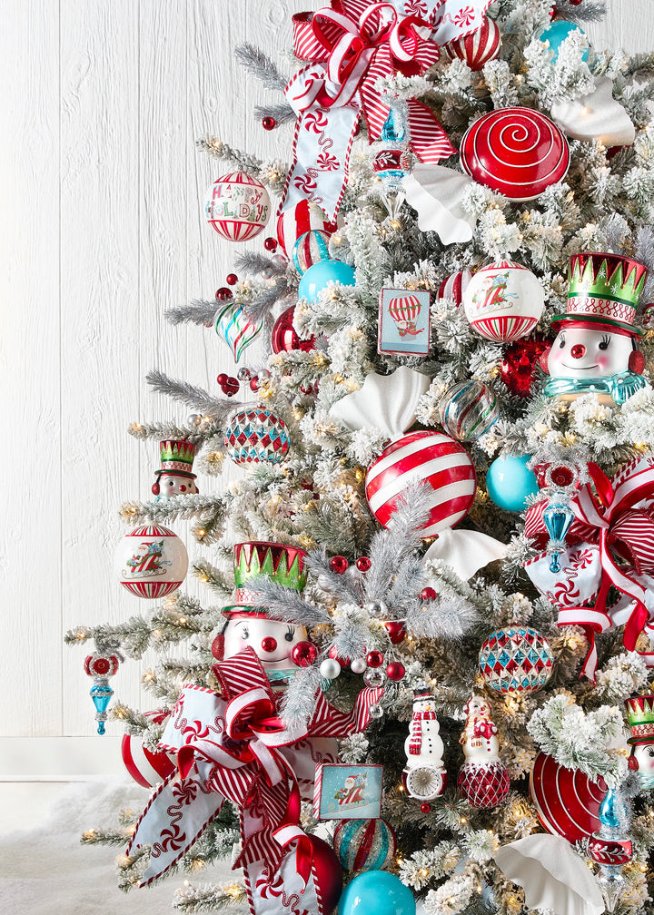 Frosted Christmas tree decorated with red, white, and turquoise Christmas ornaments, peppermint candy ribbon, striped wired ribbon, snowmen ornaments, and festive holiday décor.