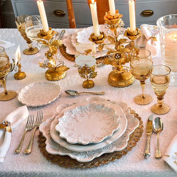 Amber gold stemmed wine glasses displayed on an elegant formal tablescape with white dinnerware and gold accents