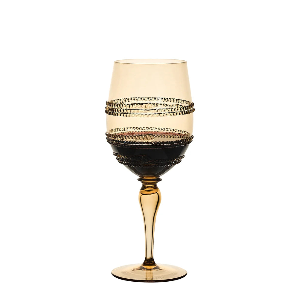 Amber gold stemmed wine glass with textured wrap detailing filled with red wine