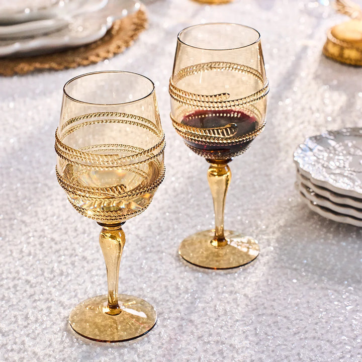Amber gold textured wine glasses filled with red and white wine on an elegant table setting