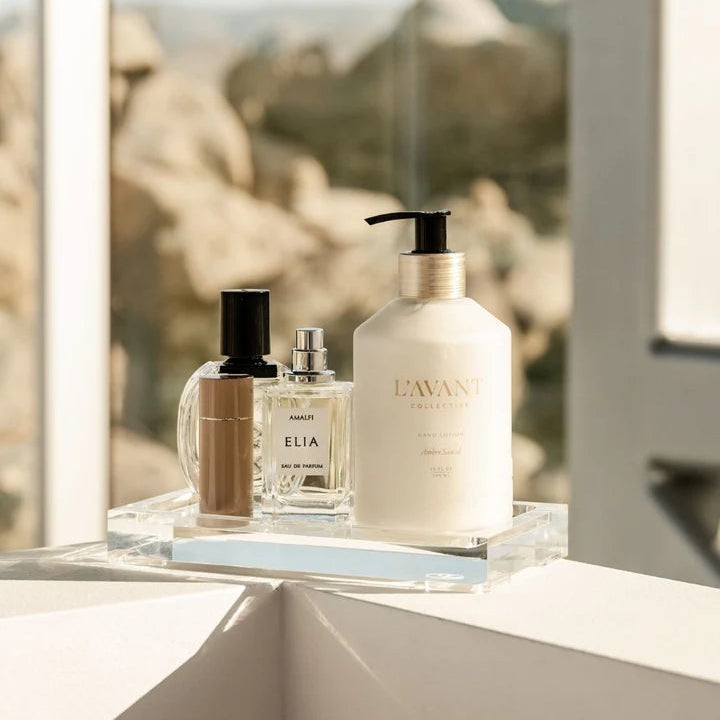 L’AVANT Collective Ambre Santal Hand Lotion displayed with matching High Performing Hand Soap on a clear acrylic tray