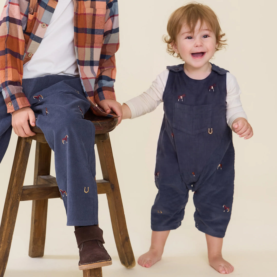 Baby boy wearing the Baby Boy Navy Horse Jumper layered over a cream long sleeve shirt