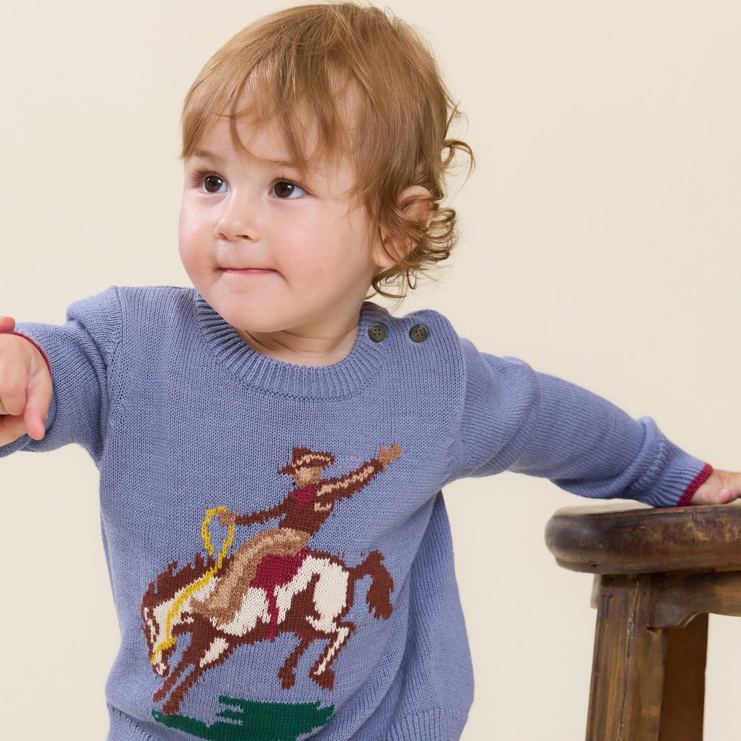 Baby boy wearing blue Bronco Sweater with cowboy and bucking horse design