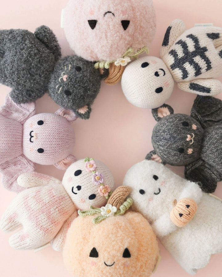 Baby Ghost with Pumpkin displayed among a collection of pastel knit Halloween toys