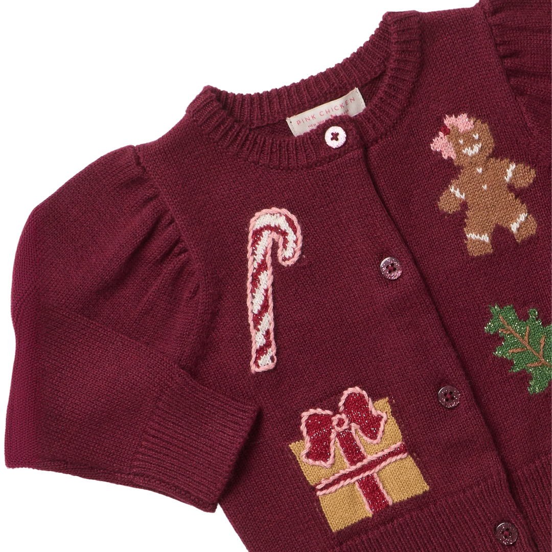 Close-up of Baby Girls Constance Sweater showing holiday patches, textured burgundy knit, puff sleeves, and button-front details.