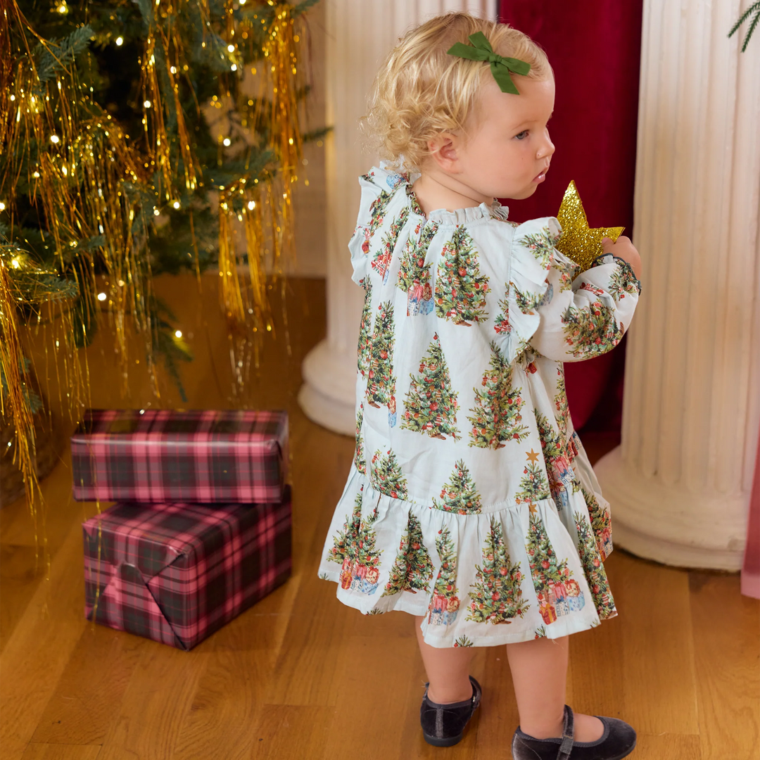 Back view of a baby girl wearing the Pink Chicken Harper Dress Set in Trees and Presents with ruffled shoulders and a festive Christmas tree print.
