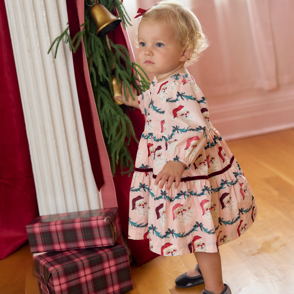 Toddler girl wearing the Pink Chicken Maribelle Dress Set in Santa Garland with festive Santa print and puff sleeves.