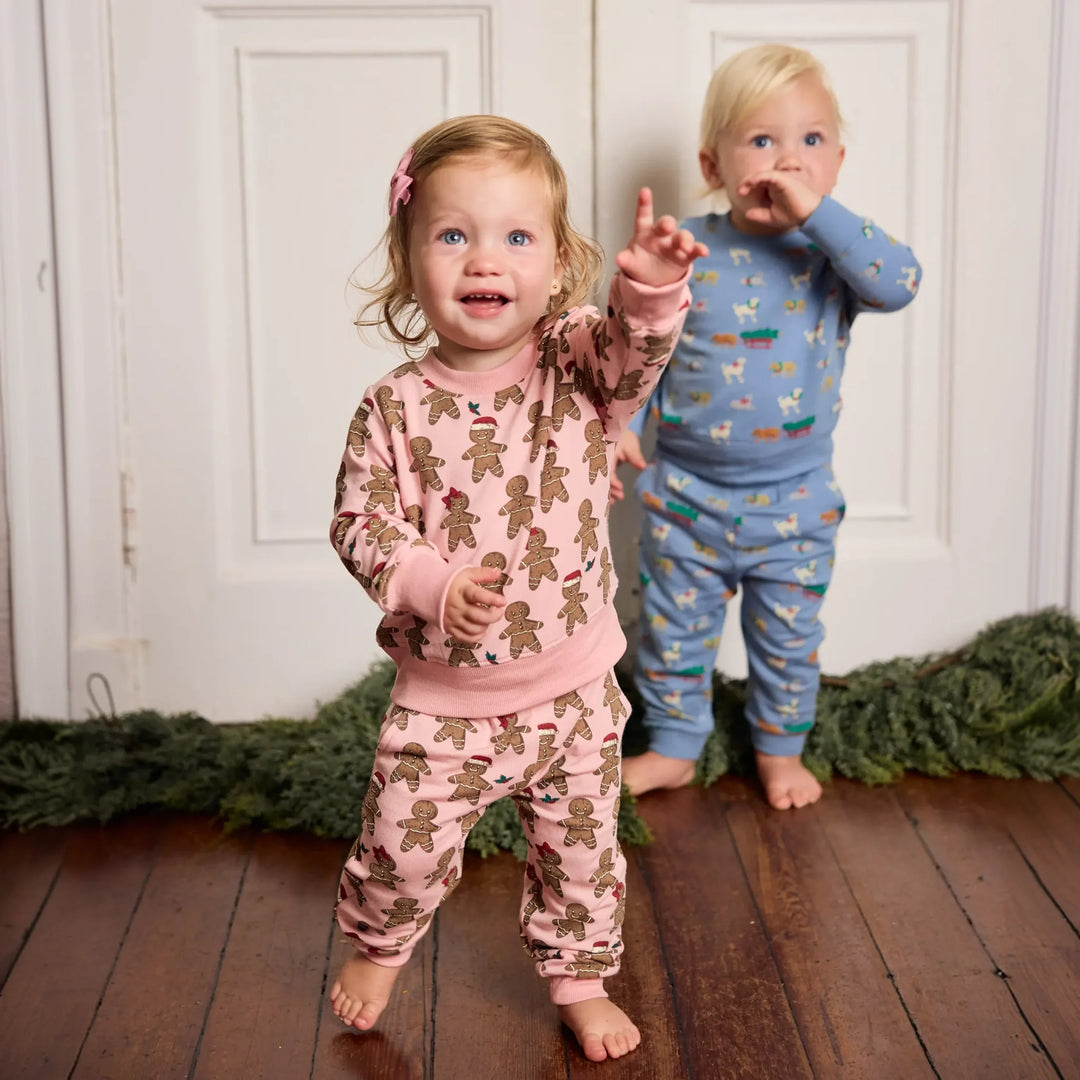 Toddler wearing pink Baby Jax Gingerbread Cookie Jogger Set with matching Christmas sweatshirt and pants