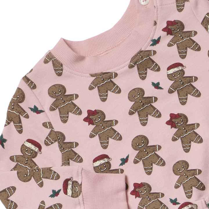 Close-up of pink Baby Jax Gingerbread Cookie sweatshirt showing festive print, ribbed neckline, and shoulder buttons