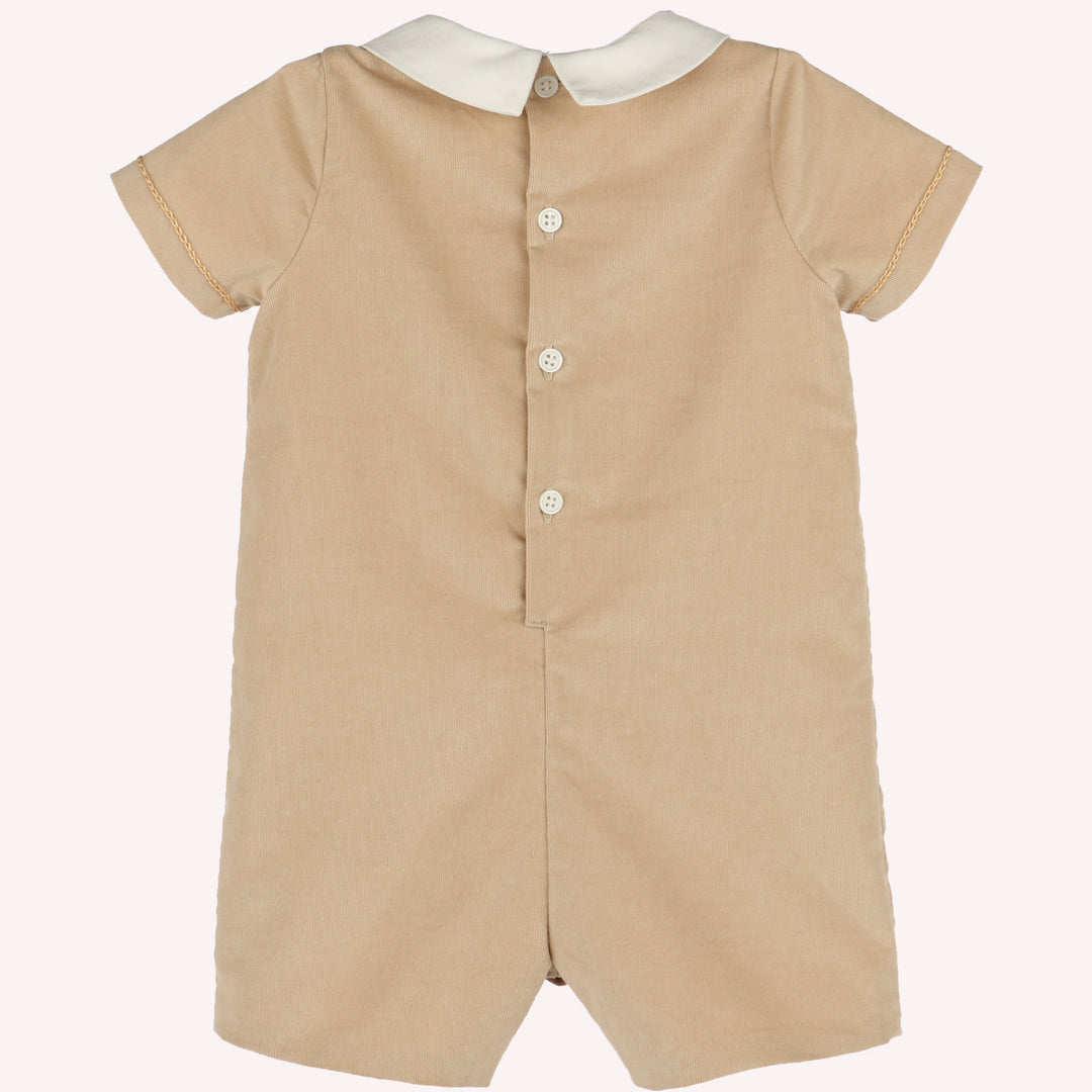 Back view of beige corduroy baby boy romper with ivory Peter Pan collar, short sleeves, and button-back closure.