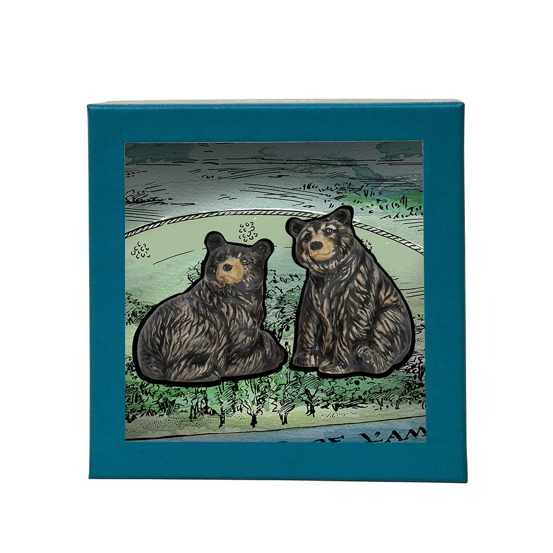 Black bear figurine pair displayed with illustrated woodland packaging, perfect for nature-inspired gifting and home decor.