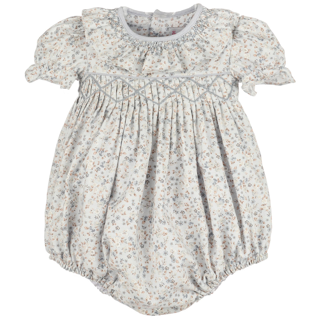 Front view of Bloomy Chintz Blue Smocked Bubble featuring a delicate blue floral print, smocked chest, ruffle collar, puff sleeves, and gathered bubble silhouette.
