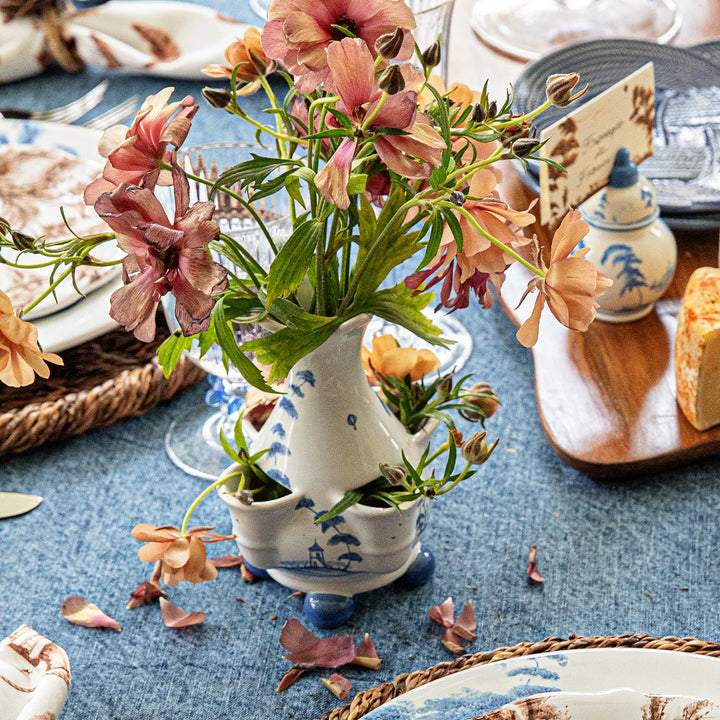 Blue and white chinoiserie multi-bud vase with fresh flowers displayed on an elegant blue dining tablescape
