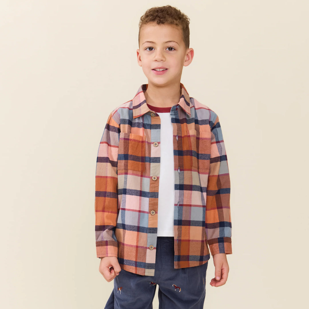 Boy wearing the Boys Hayride Plaid Shirt layered over a white tee