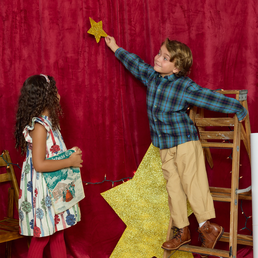 Boy wearing Pink Chicken Blue Tartan Jack Shirt while decorating for Christmas