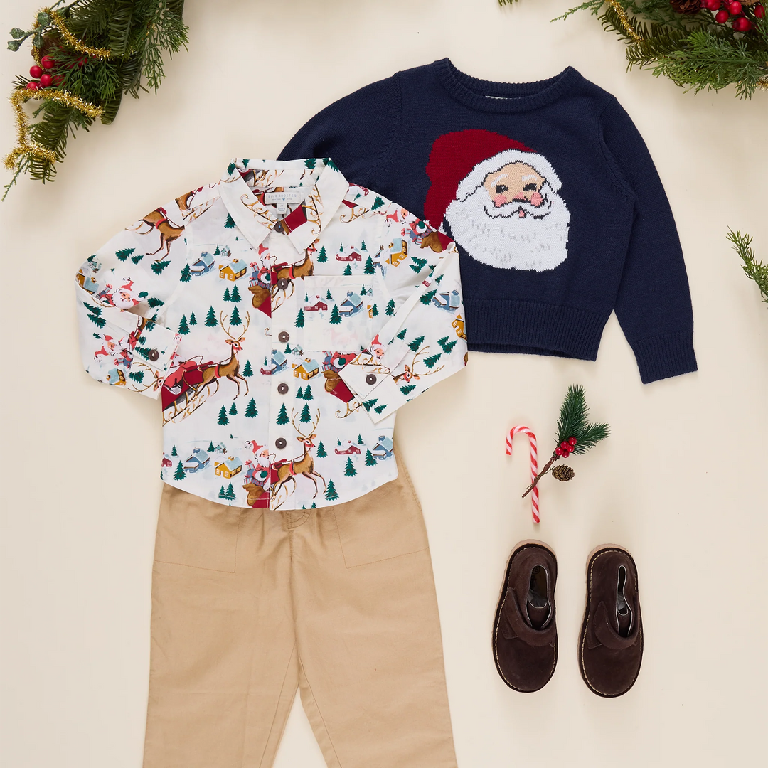 Pink Chicken Navy Santa Oliver Sweater styled with a Christmas button-down shirt, khaki pants, and brown shoes