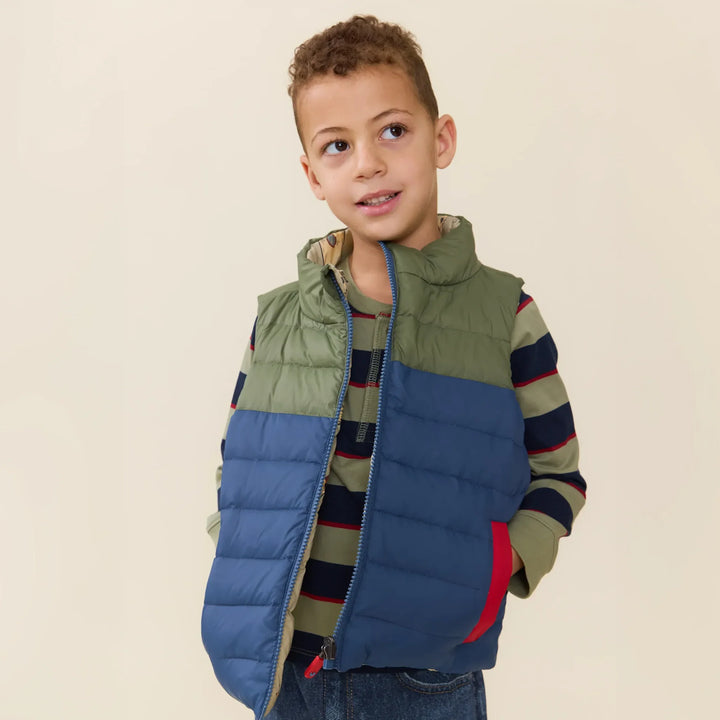 Boy wearing the Reversible Riley Vest Space Rocket on the blue and green side