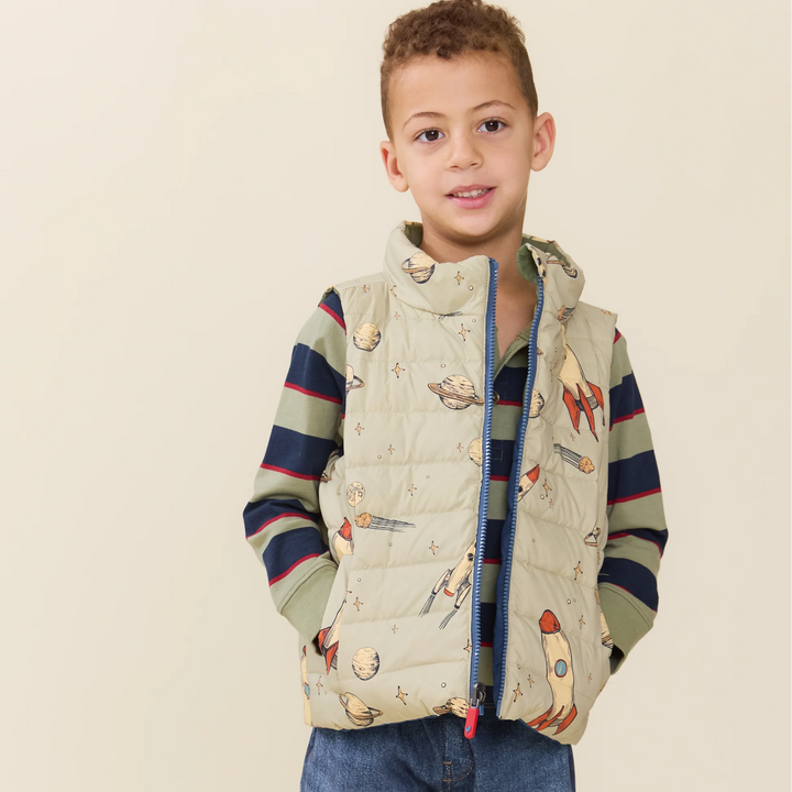 Boy wearing the Reversible Riley Vest Space Rocket with planets and rockets print