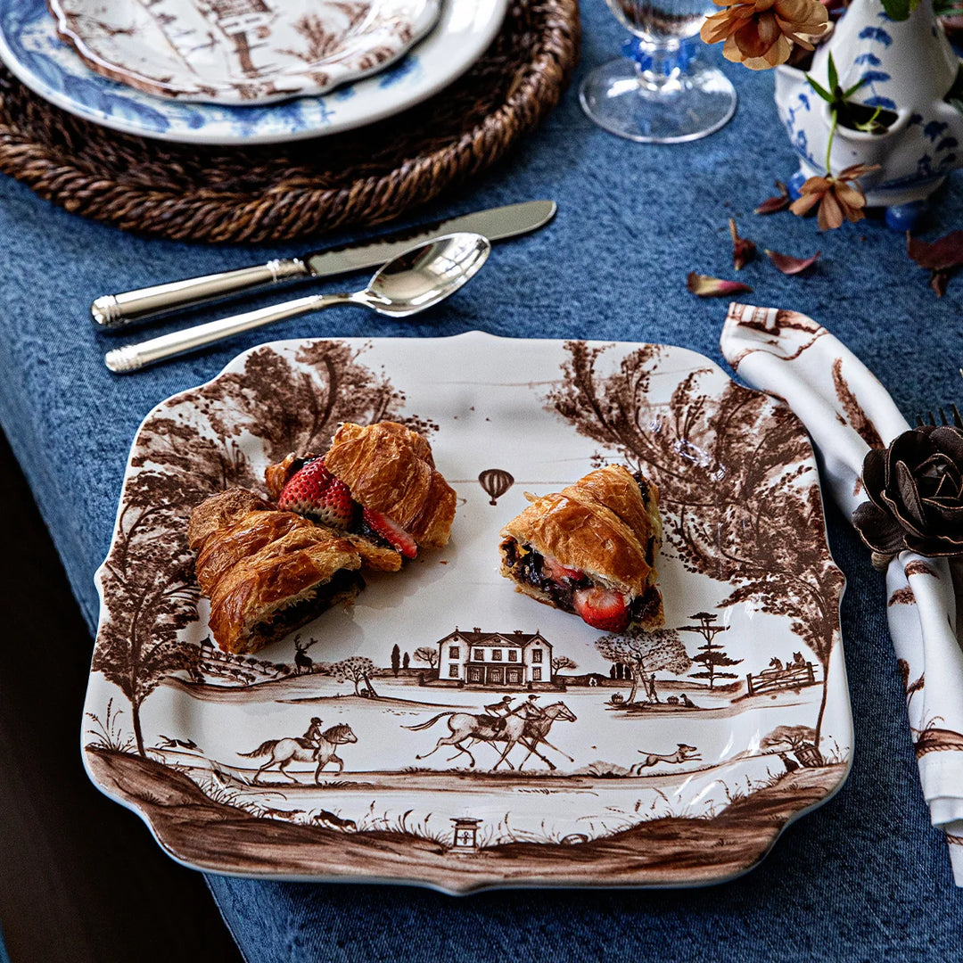 Brown toile square serving platter with pastries displayed on an elegant blue and brown toile table setting