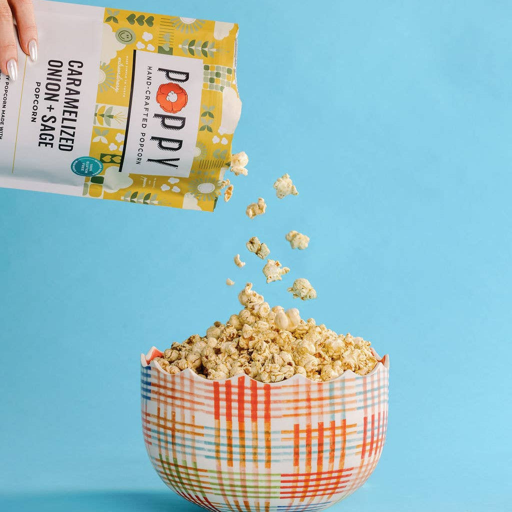 Poppy Caramelized Onion + Sage popcorn being poured into a serving bowl