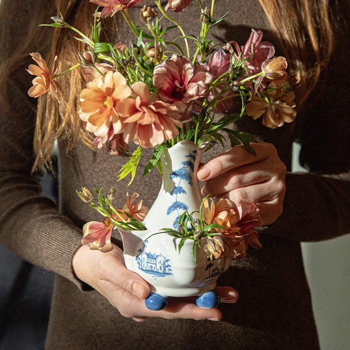 Blue and white chinoiserie bud vase filled with pink and peach flowers and styled as a dining table centerpiece