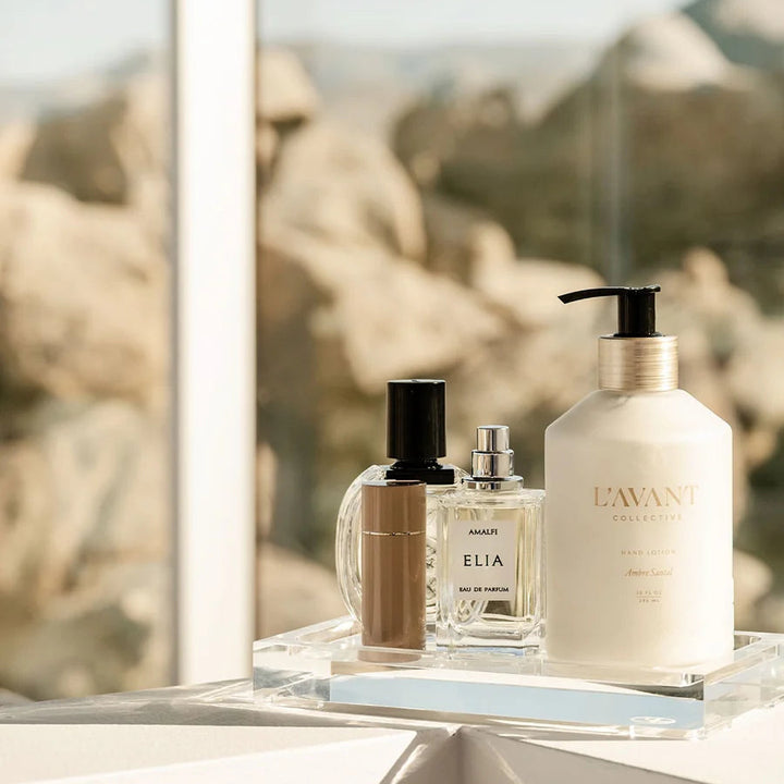 Clear acrylic vanity tray styled with perfume, fragrance, and hand lotion for an elegant bathroom or dressing table display.