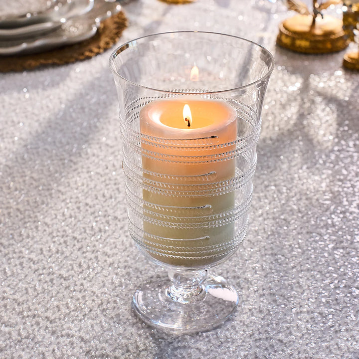 Clear glass hurricane candle holder with decorative wrapped glass detailing and a lit ivory pillar candle