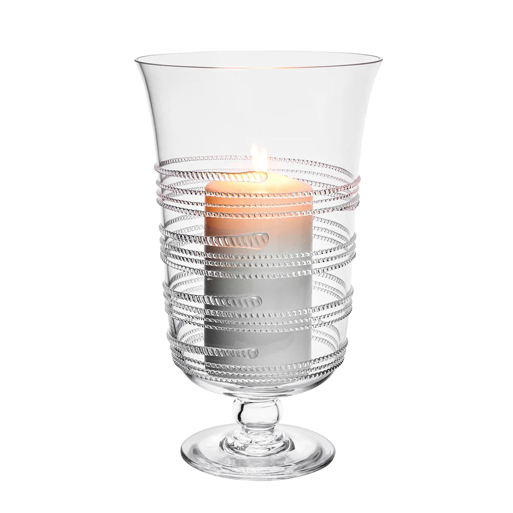 Clear footed glass hurricane candle holder with textured glass bands and an ivory pillar candle
