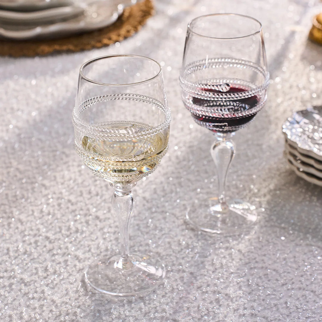 Clear textured wine glasses filled with red and white wine on an elegant dining table