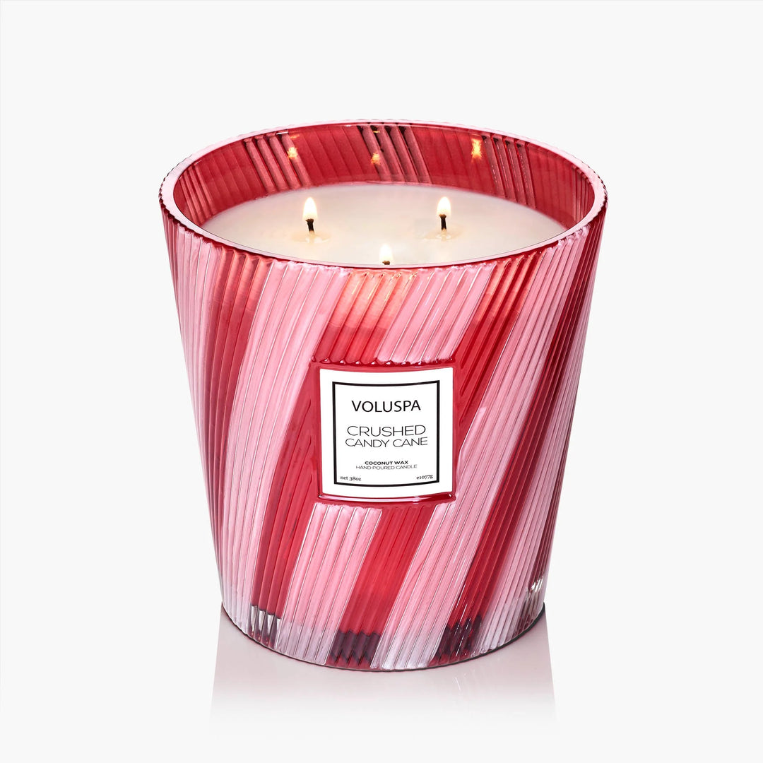 Crushed Candy Cane 3 Wick Hearth Candle burning in red and white striped glass vessel