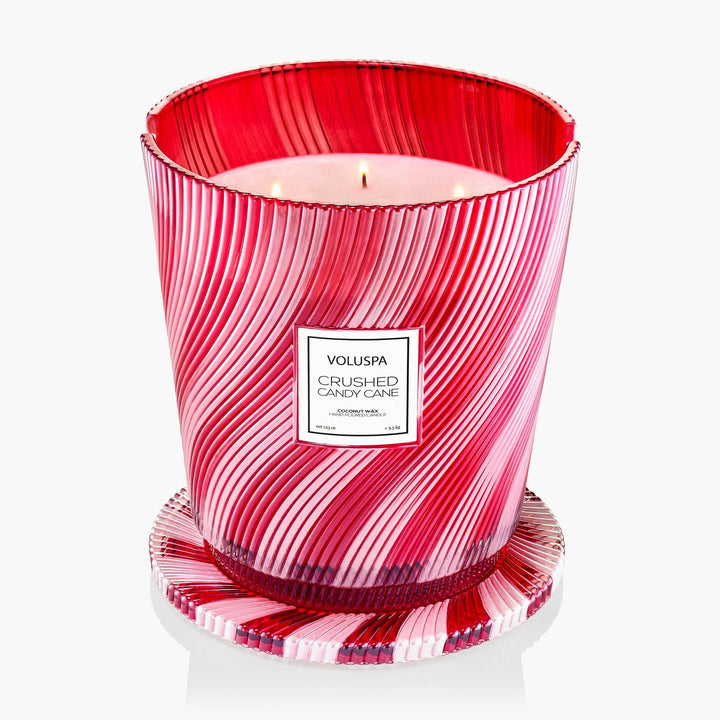 Lit Voluspa Crushed Candy Cane 5 Wick Hearth Candle with decorative red and white striped glass lid