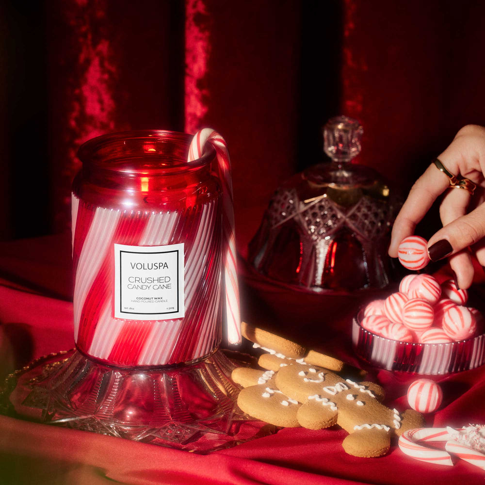 Crushed Candy Cane Large Jar Candle styled with peppermint candies and gingerbread cookies for Christmas