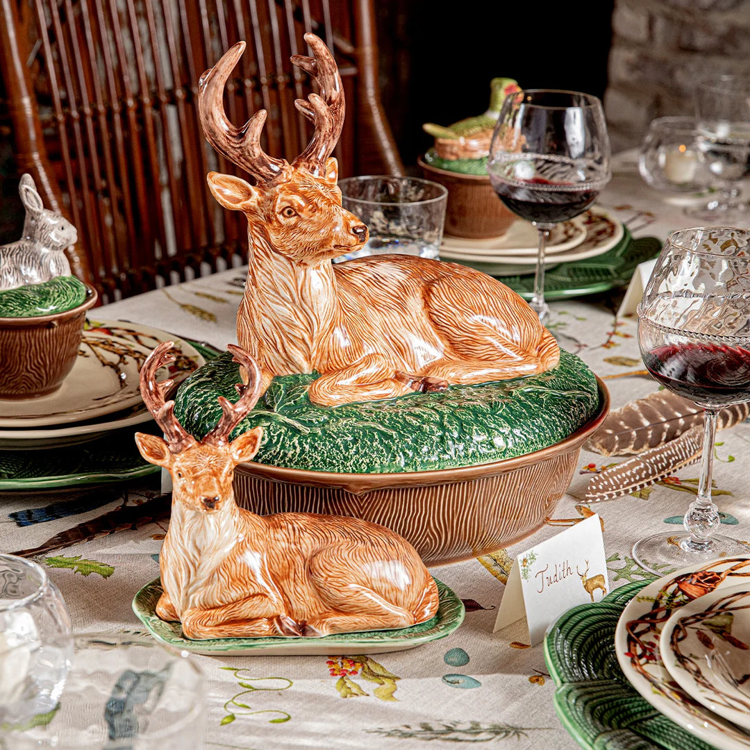 Deer covered serving dish styled on an elegant woodland tablescape with coordinating wildlife dinnerware and wine glasses.