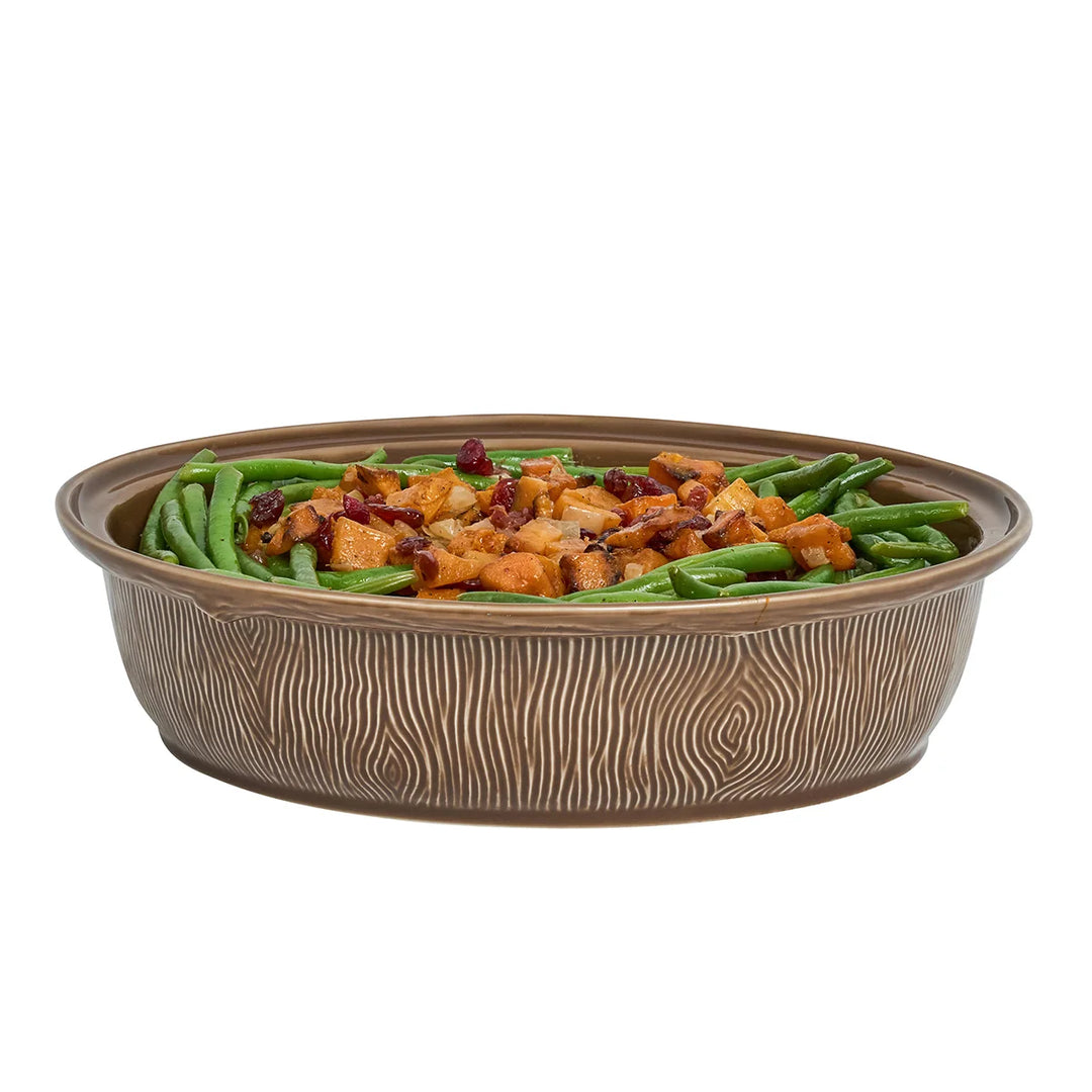 Oval brown ceramic deer serving bowl filled with green beans and roasted vegetables, showing the dish without its decorative lid.