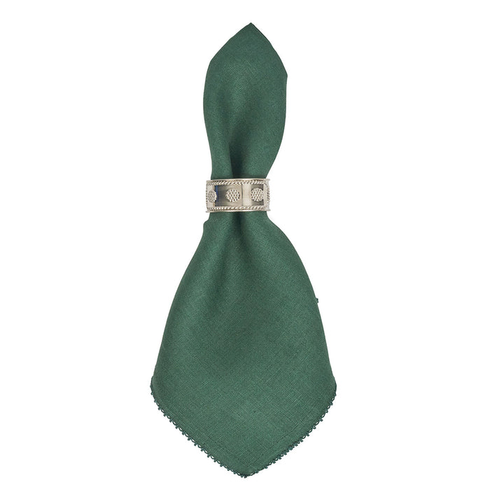 Forest green linen napkin styled with a silver napkin ring for an elegant dinner or holiday table setting.