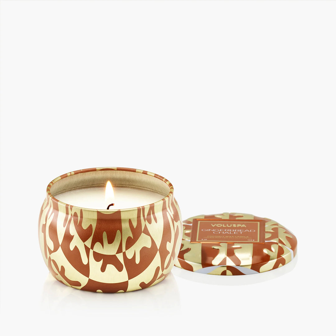 Lit Gingerbread Chalet Mini Tin Candle by Voluspa with decorative brown and gold lid