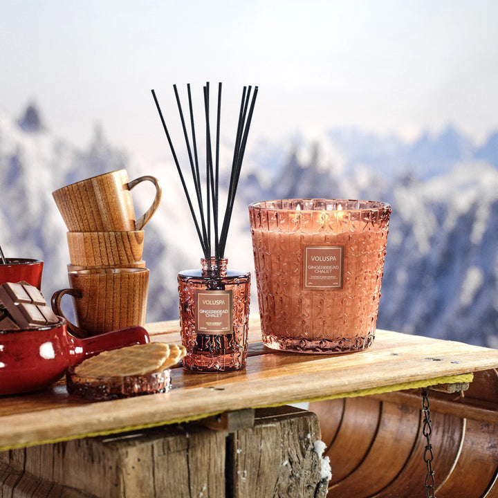 Gingerbread Chalet Reed Diffuser by Voluspa styled with coordinating candle in a cozy winter holiday setting