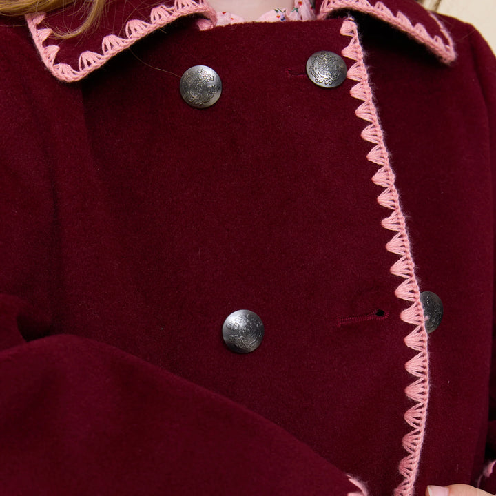 Close-up of Girls Beck Peacoat Burgundy featuring decorative metal buttons and contrasting pink trim