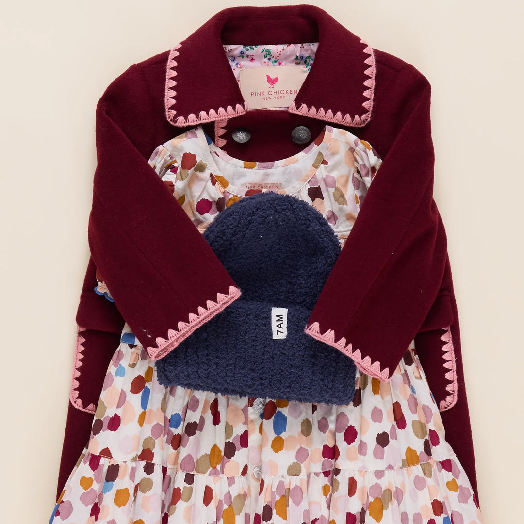 Girls Beck Peacoat Burgundy styled with a printed dress and navy knit hat for a fall outfit