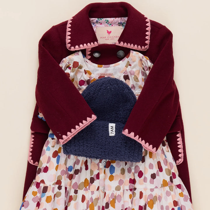 Girls Beck Peacoat Burgundy styled with a printed dress and navy knit hat for a fall outfit