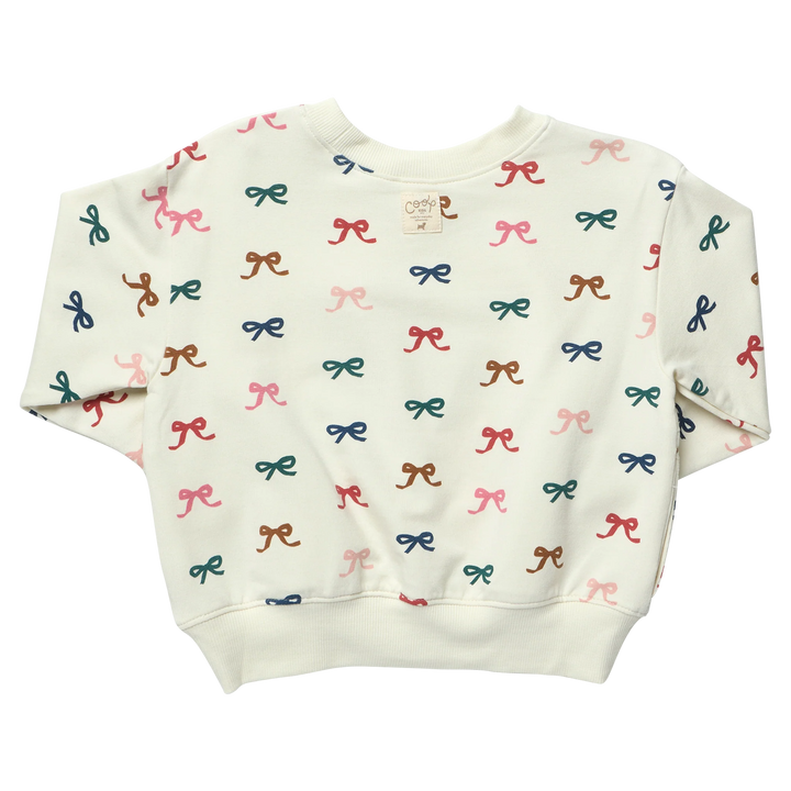 Back view of cream girls sweatshirt featuring an all-over colorful bow print and ribbed hem, cuffs and crew neckline