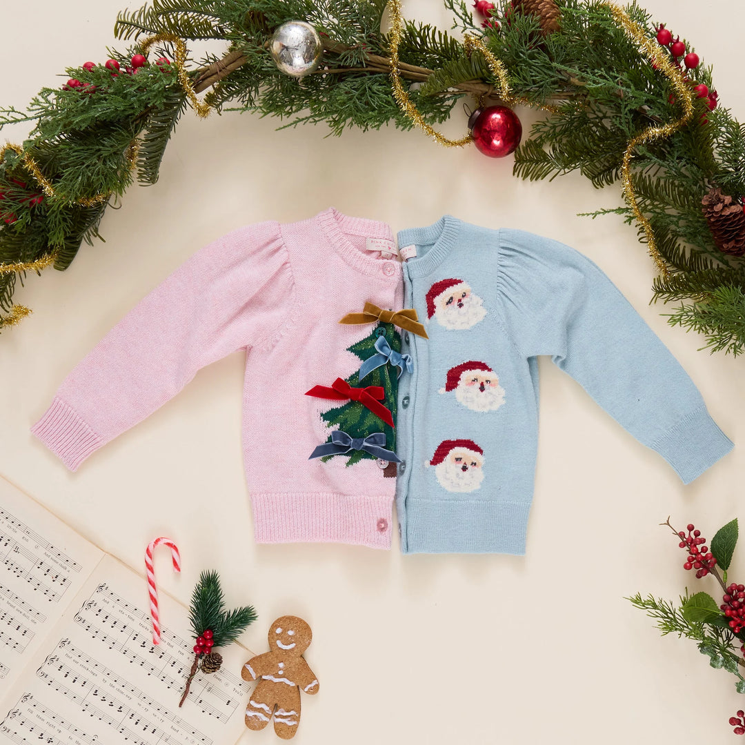 Pink Chicken Tossed Santas cardigan styled alongside a pink Christmas tree cardigan with festive holiday decorations