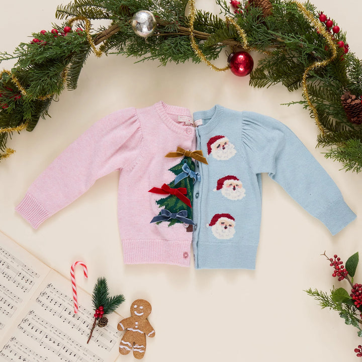 Pink Chicken Tossed Santas cardigan styled alongside a pink Christmas tree cardigan with festive holiday decorations