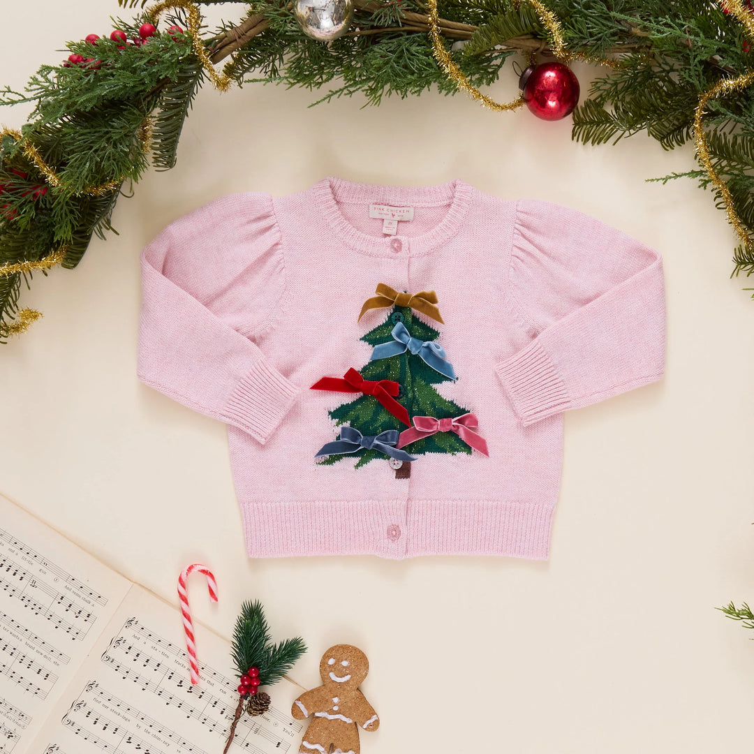 Pink Chicken Girls Constance Sweater in Tree Bows styled flat with Christmas greenery, ornaments, candy cane, and gingerbread cookie