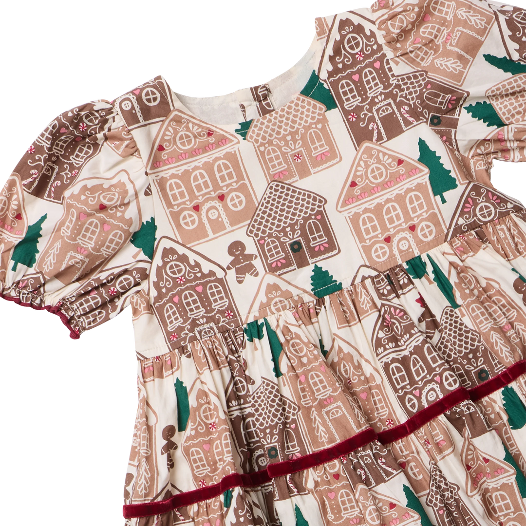 Close-up of the Girls Eliza Dress showing gingerbread houses, Christmas trees, puff sleeves, gathered waist, and burgundy velvet trim.