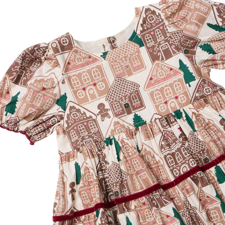 Close-up of the Girls Eliza Dress showing gingerbread houses, Christmas trees, puff sleeves, gathered waist, and burgundy velvet trim.