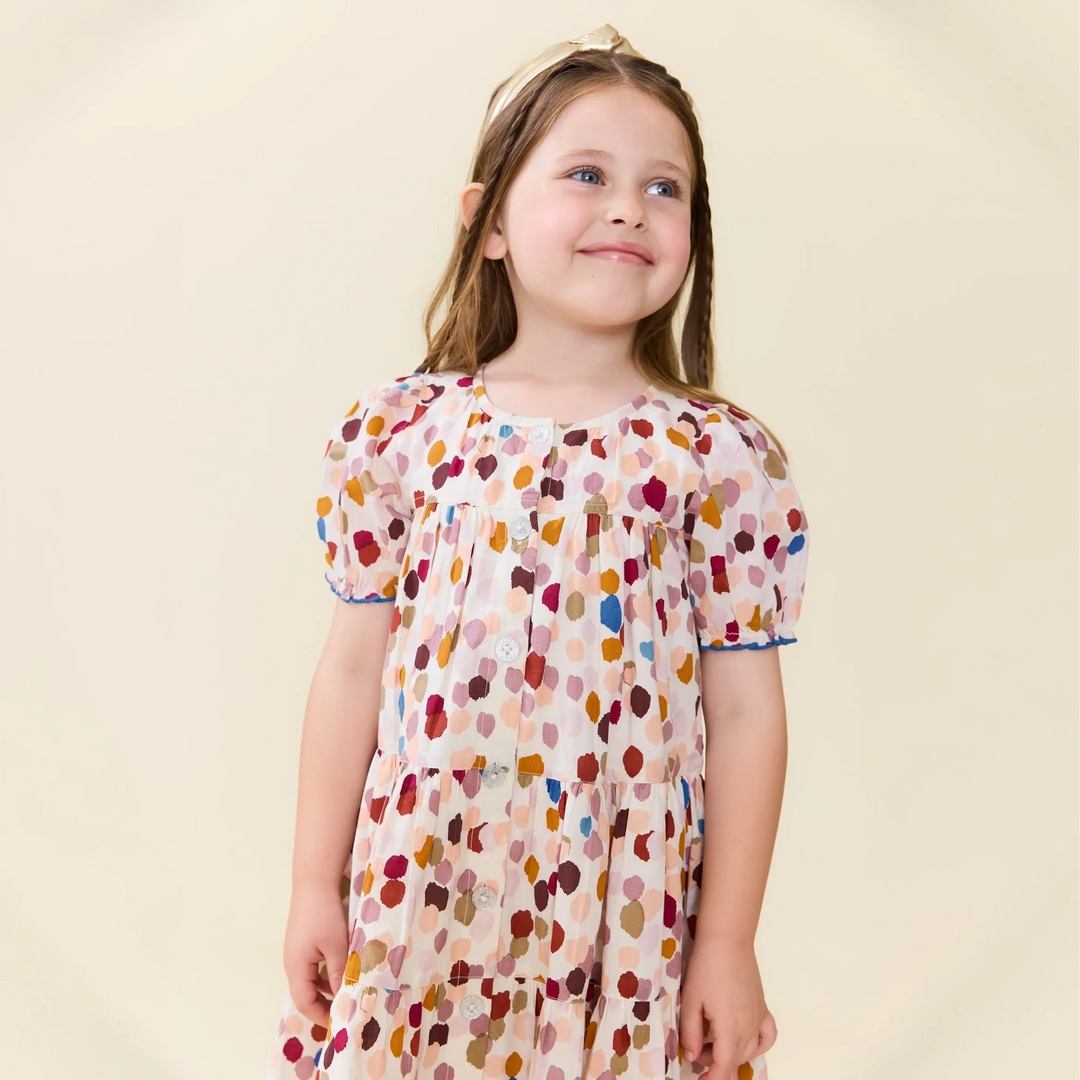 Girl modeling the Elizabeth Dress in Autumn Spots featuring a colorful fall print and short puff sleeves