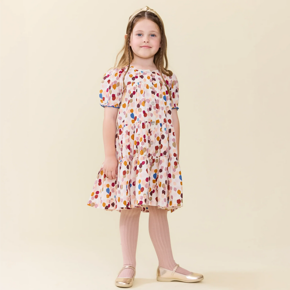 Girl wearing the Elizabeth Dress in Autumn Spots with pink tights and gold shoes