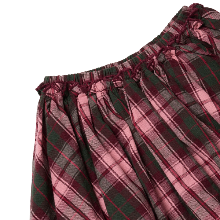 Close-up of the Girls Gianna Skirt in Burgundy Tartan showing the gathered elastic waistband, delicate burgundy ruffle trim, and pink and green plaid pattern.